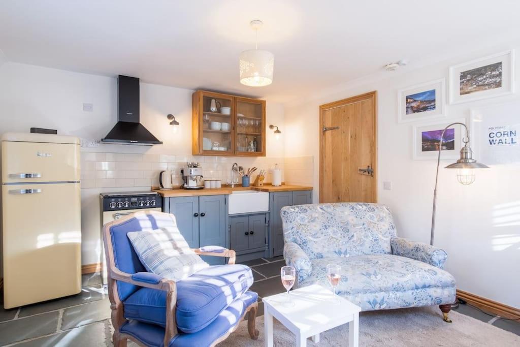a kitchen with a couch and a chair and a table at Bijou Coastal Apartment in Polperro with Onsite Parking in Polperro