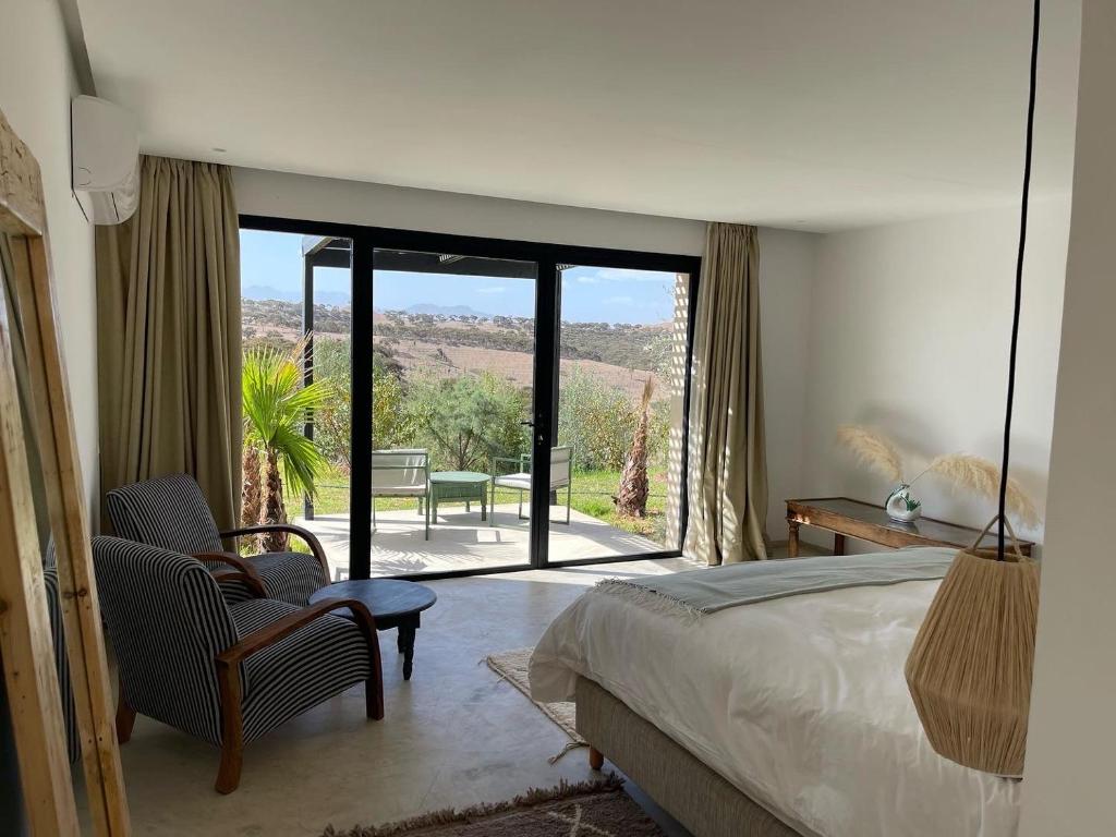 a bedroom with a bed and a view of a patio at Lahô Lodge in Lalla Takerkoust