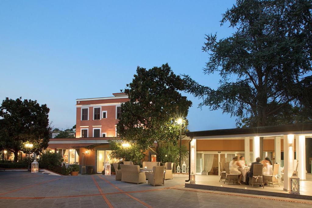 a group of people sitting in chairs outside of a building at Montespina Park Hotel in Naples