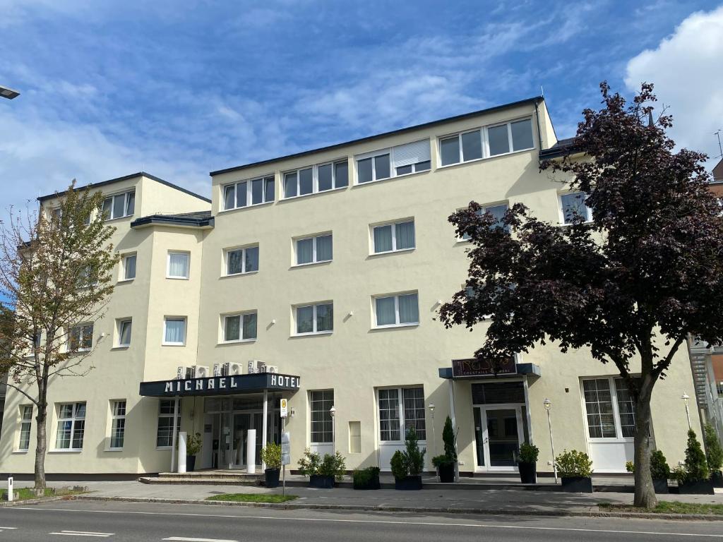 ein großes weißes Gebäude an der Straßenseite in der Unterkunft Hotel Michael in Gerasdorf bei Wien