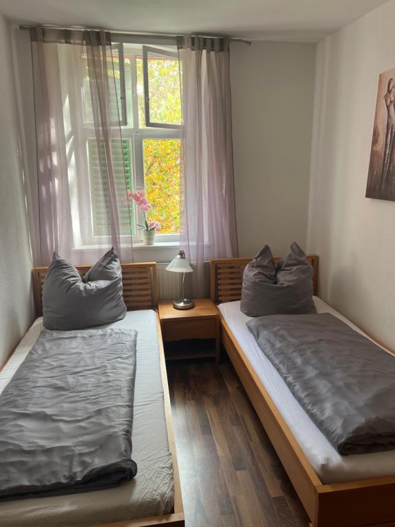 2 Betten in einem Zimmer mit Fenster in der Unterkunft Gästehaus Stern in Schwabach