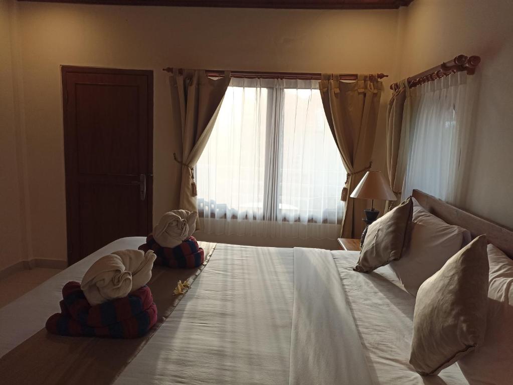 Postel nebo postele na pokoji v ubytování Kusnadi Hotel