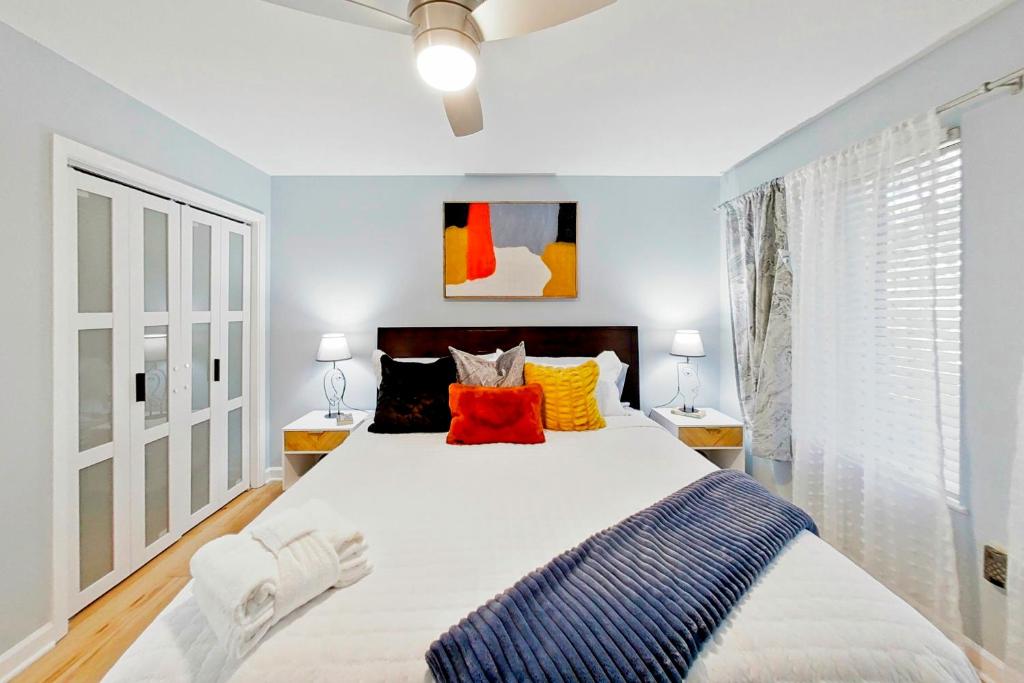a bedroom with a large bed with orange and blue pillows at Bijou De La Beach in Hilton Head Island