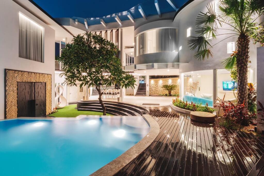 a large house with a swimming pool in a yard at Villa Rose in Seminyak