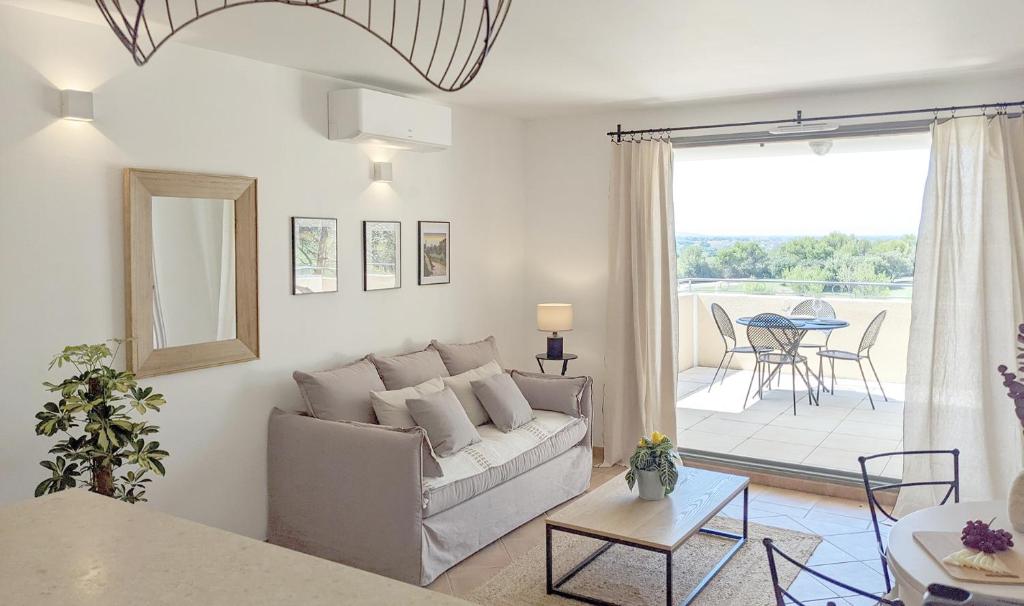 uma sala de estar com um sofá e um pátio em ALLURA GOLF APPARTEMENT em Saumane-de-Vaucluse