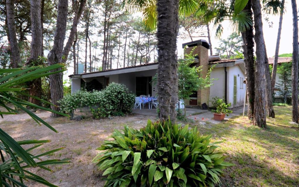 ein Haus inmitten eines Gartens mit Bäumen in der Unterkunft Villa Stefania in Lignano Sabbiadoro