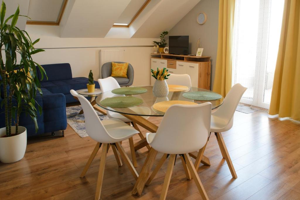 a dining room with a table and white chairs at Eliza 1 Birdland Golf Apartman in Bük