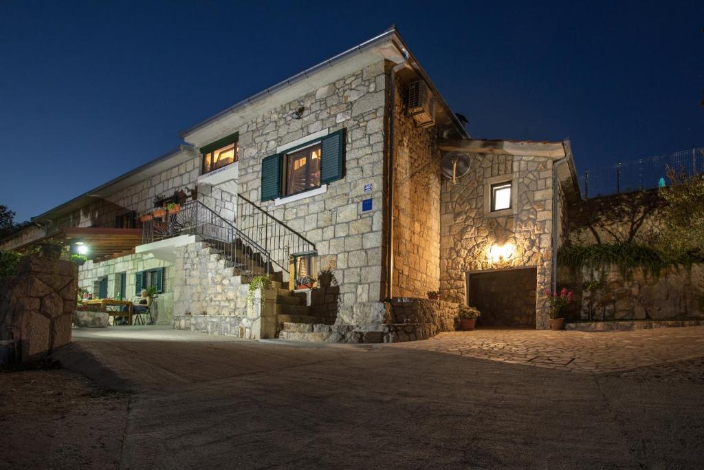 un bâtiment en pierre avec un escalier sur son côté dans l'établissement Antini dvori, à Imotski