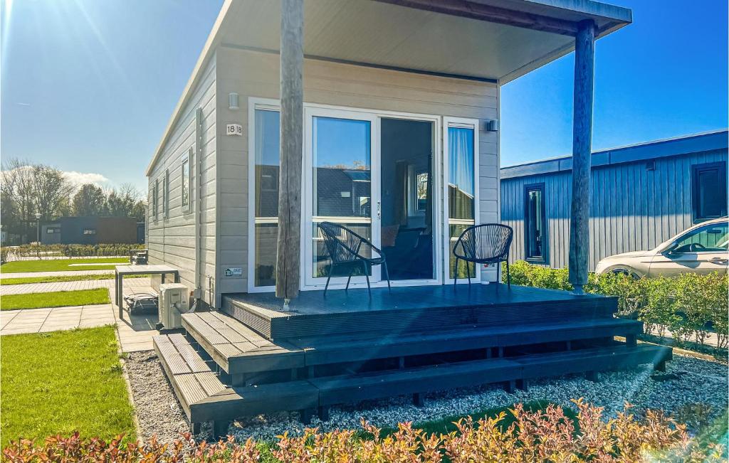 a house with a porch with a chair on it at Stunning Home In Scherpenisse in Scherpenisse