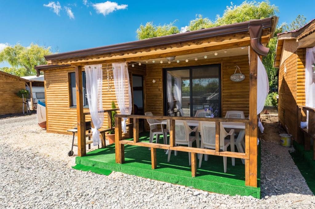 a wooden cabin with a table and chairs outside at ECO Hоuses - Camping Gradina in Chernomorets