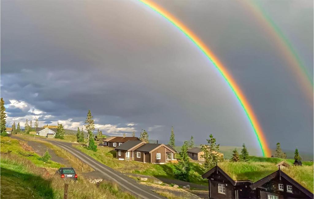 un arco iris en el cielo sobre una casa en Stunning Home In Sjusjen With House A Mountain View en Sjusjøen