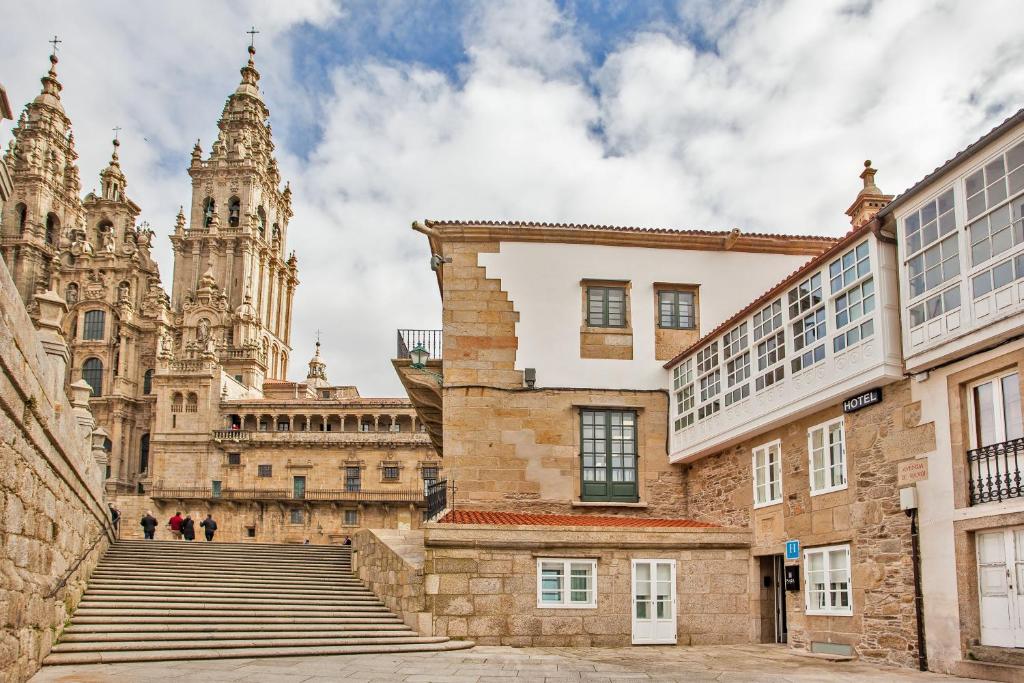 een uitzicht op een gebouw met trappen en een kathedraal bij Hotel Plaza Obradoiro by Bossh! Hotels in Santiago de Compostela