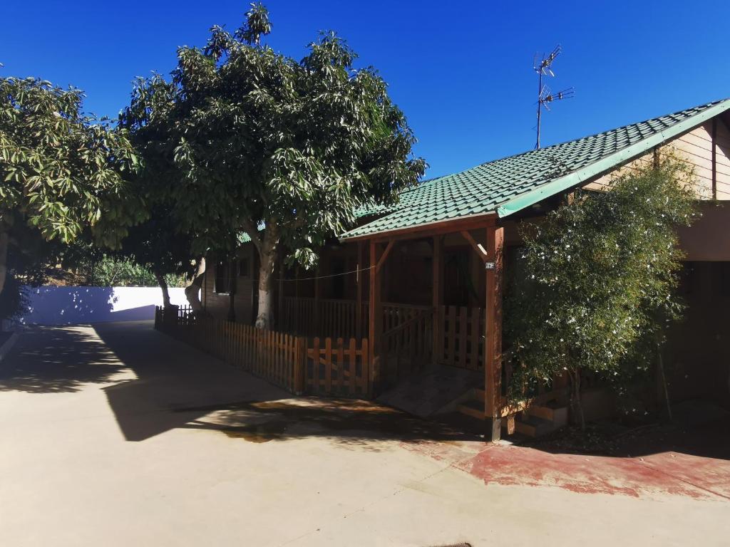 Casa con porche de madera con valla en Bungalow con piscina en camping privado cerca de la playa de Torre del Mar Ideal familias en Vélez-Málaga