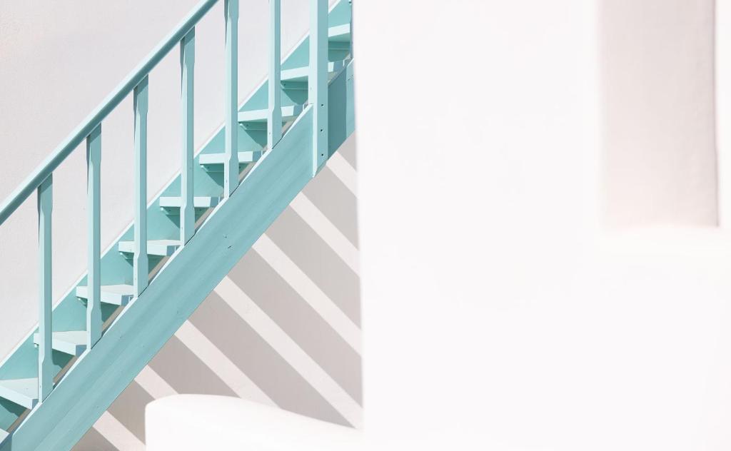 a staircase in a building with blue rails at Ploes Seaside Houses in Plaka