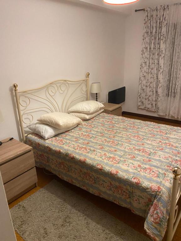1 dormitorio con 1 cama, mesita de noche y ventana en Apartamento F.A, en Pedrógão