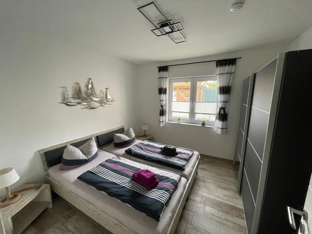 1 dormitorio con 2 camas y ventana en Ferienhaus Meerzeit, en Bastorf