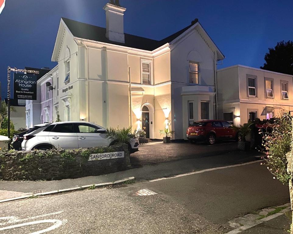 a white house with a car parked in front of it at Abingdon House in Torquay