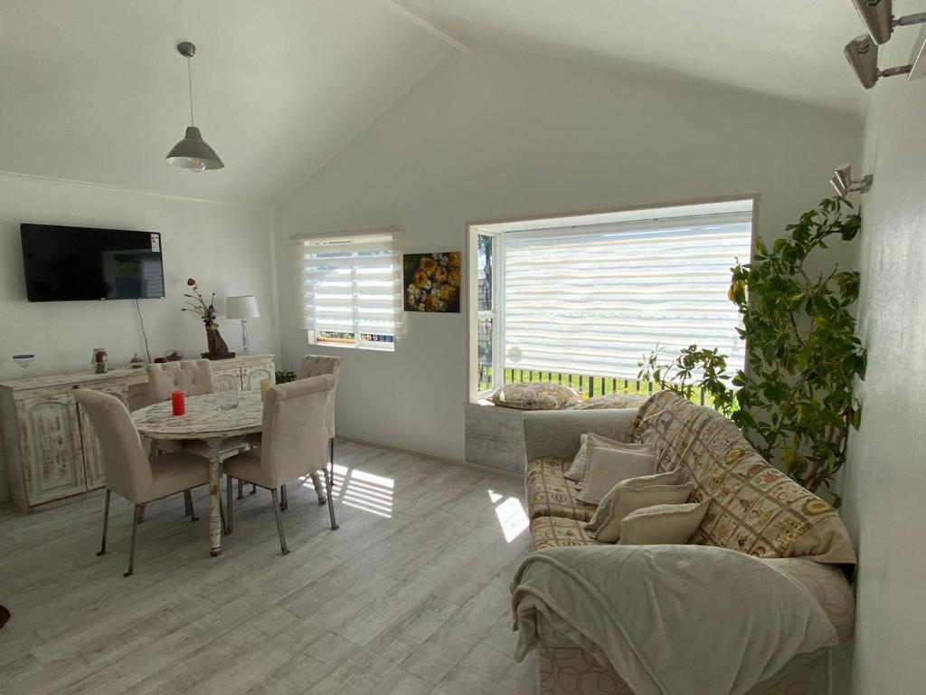 uma sala de estar com um sofá e uma mesa em Acogedor bungalow house en barrio residencial em Puerto Montt