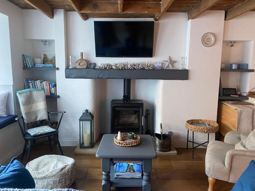 a living room with a fireplace and a flat screen tv at Shrimp Cottage - 3 bed renovated cottage with stunning sea views in Staithes