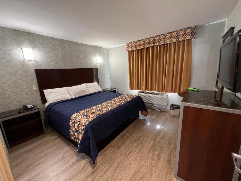 een hotelkamer met een bed en een flatscreen-tv bij Atlantic Motor Inn in Brooklyn