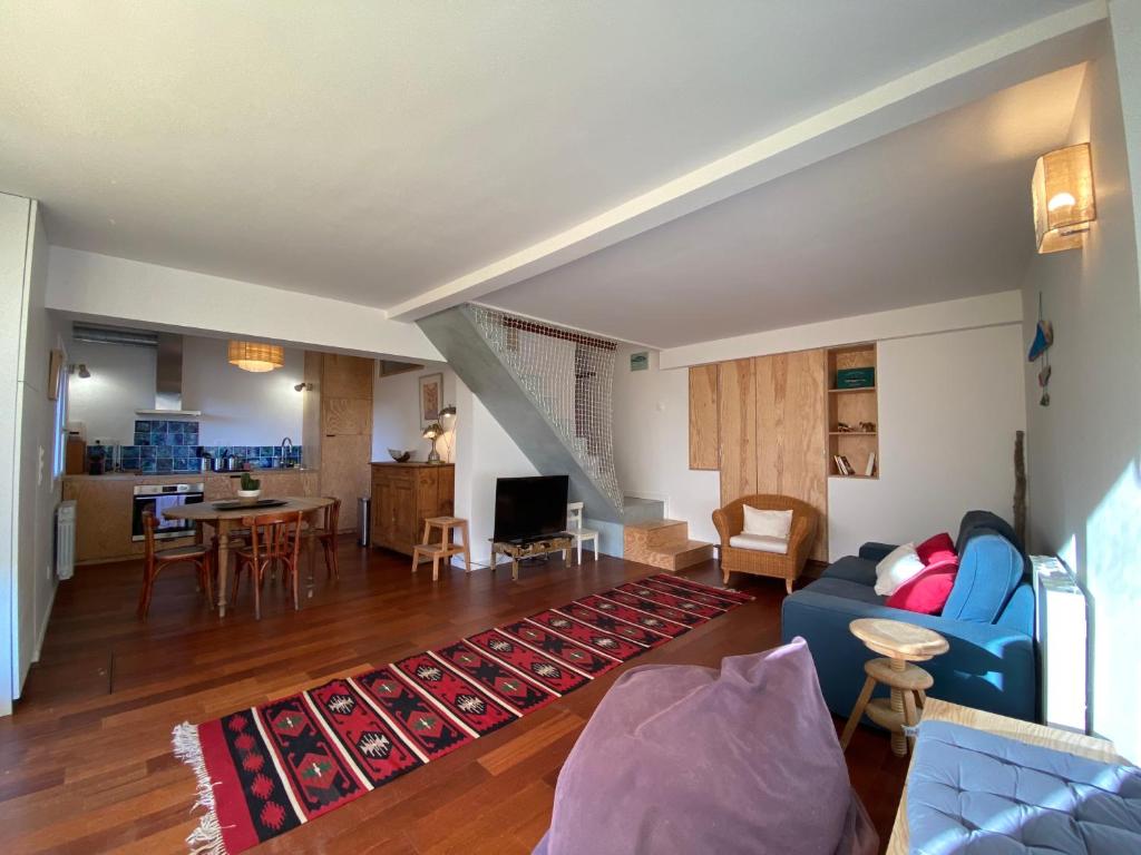 un salon avec un canapé bleu et une cuisine dans l'établissement Maison de charme avec jardin et terrasse, à Camblanes-et-Meynac