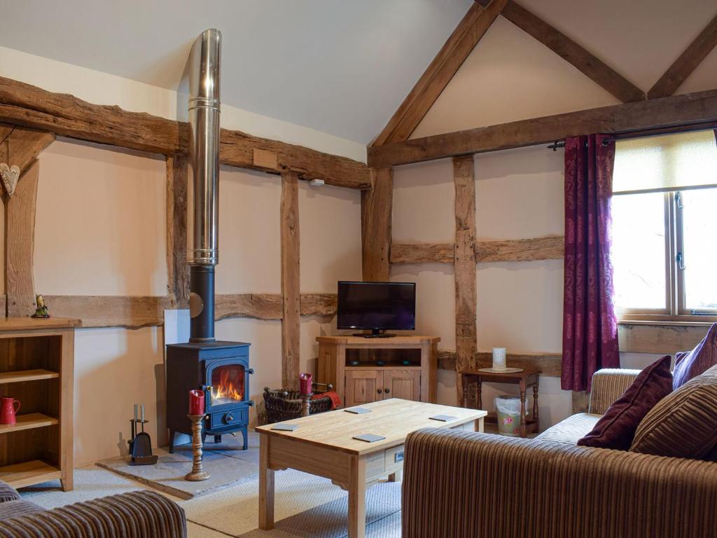 ein Wohnzimmer mit einem Holzofen im Zimmer in der Unterkunft The Granary in Kingsland
