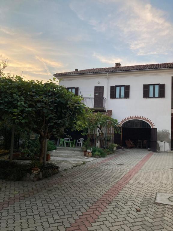 a large white house with a brick driveway at Casa Aromi ed Arte in Asti