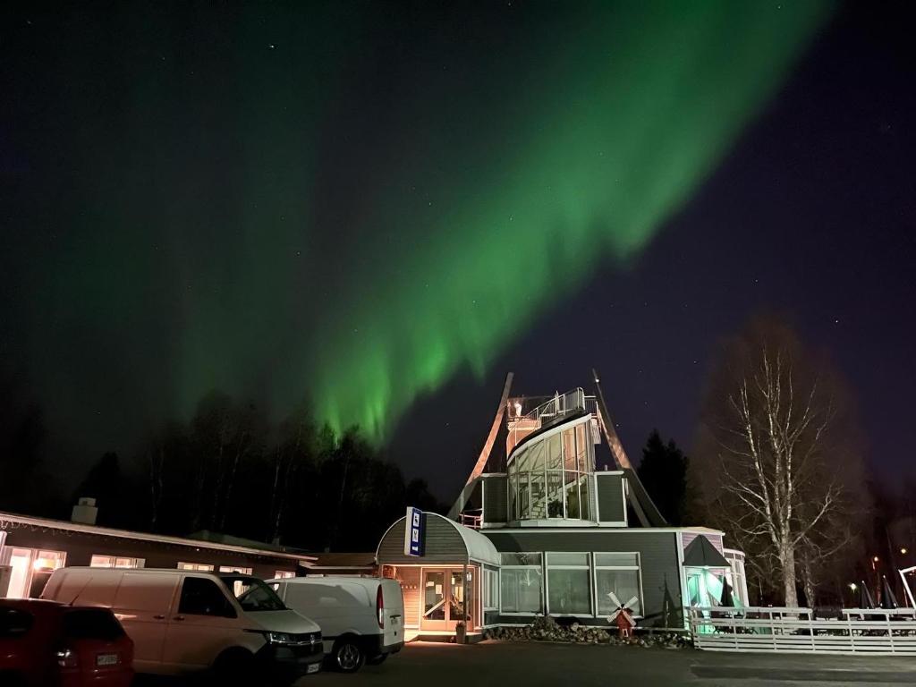 an image of a house with the aurora in the sky at Hotel Yöpuu in Kemi