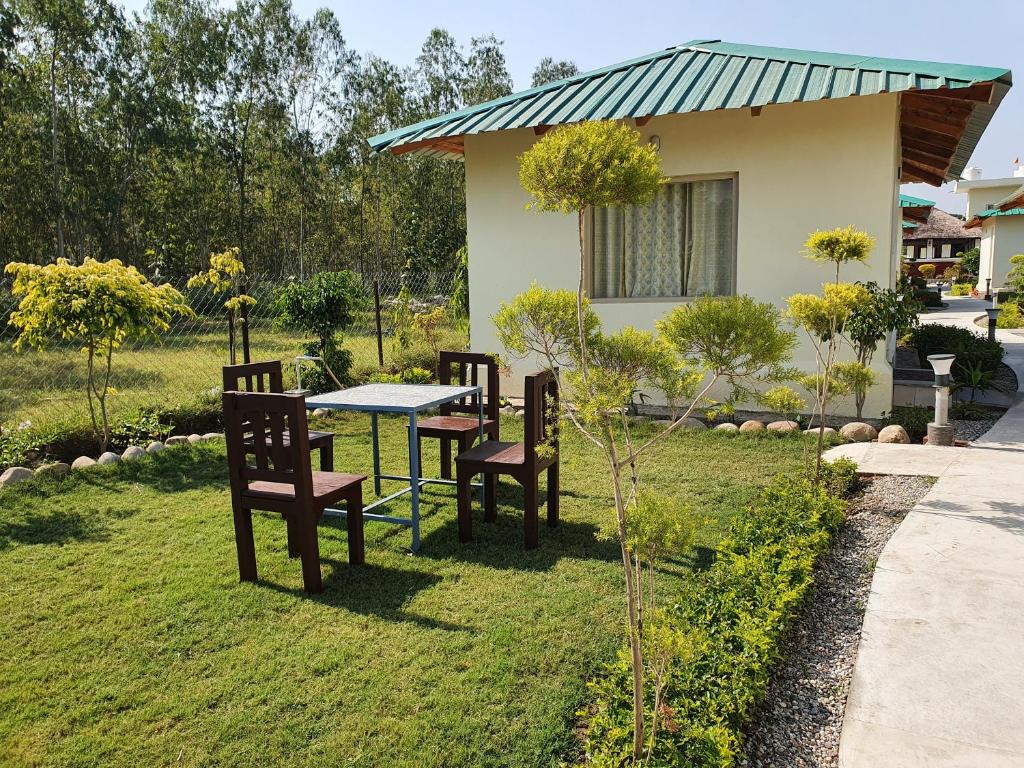 a table and chairs in the yard of a house at The Tiger Claw Resort in Rāmnagar