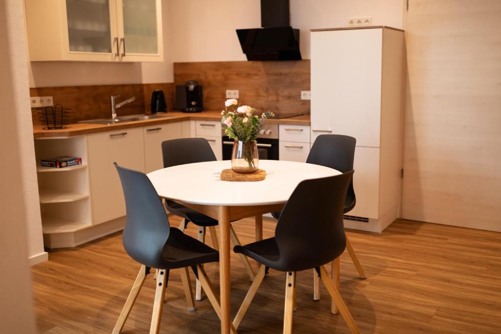 een keuken met een witte tafel en zwarte stoelen bij Urlaubsoase Moselglück in Kröv