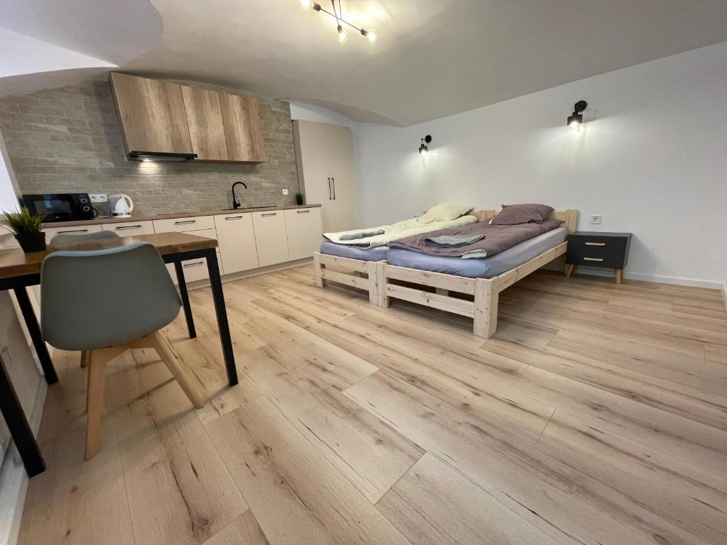 a bedroom with a bed and a table and a kitchen at Modern guest house in city center I Room 1 in Vilnius