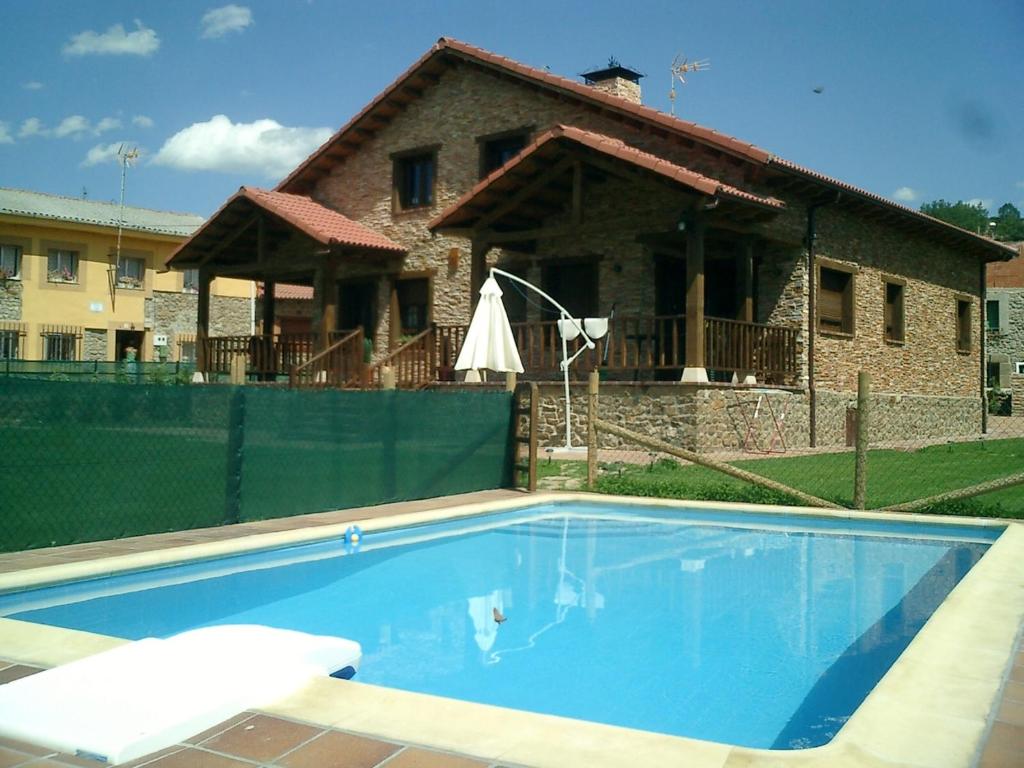 uma piscina em frente a uma casa em Casa de turismo rural San Martín de valdetuejar em San Martín de Valdetuéjar