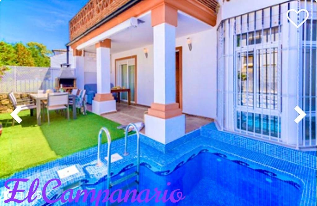 a villa with a swimming pool in front of a house at Casa El Campanario in El Bosque