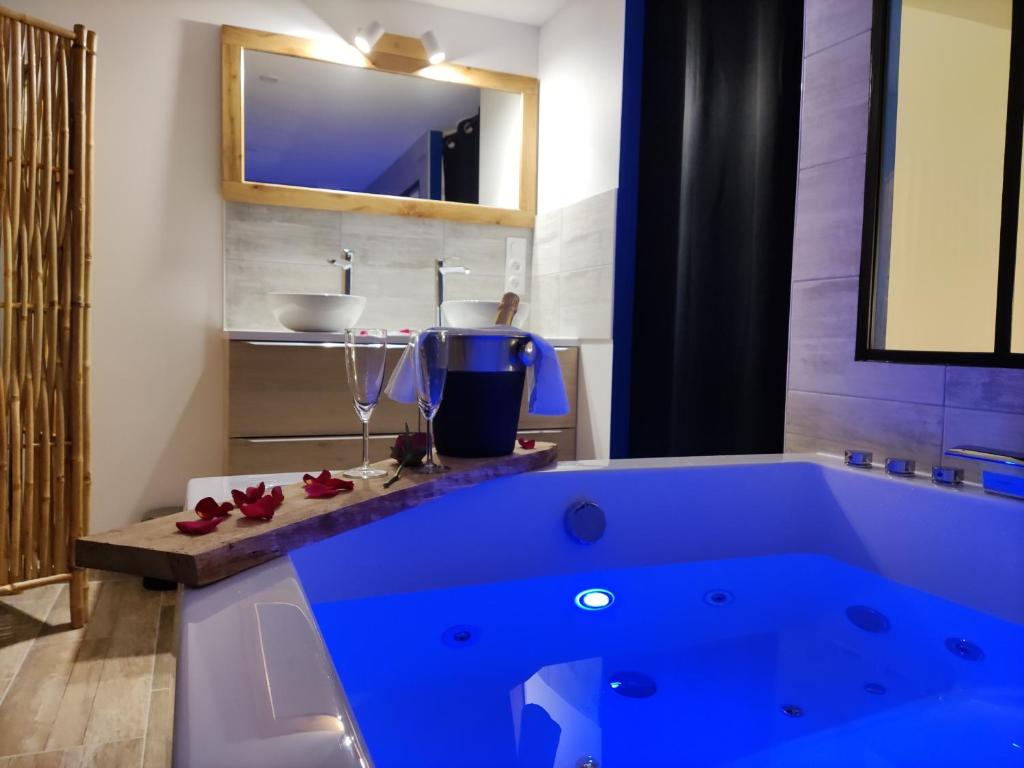 eine große blaue Badewanne im Bad mit Waschbecken in der Unterkunft Maison de ville, SPA Balnéo, 2 suites parentales in Vichy