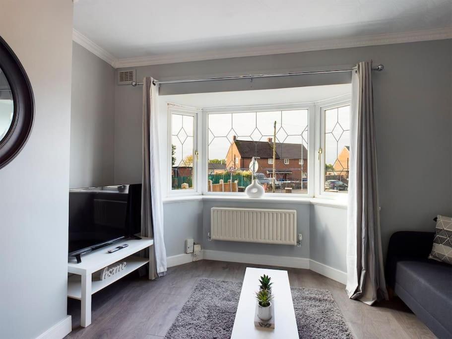 ein Wohnzimmer mit einem Sofa und einem Fenster in der Unterkunft Stunning Family Home with Comfortable Surroundings in Wigan