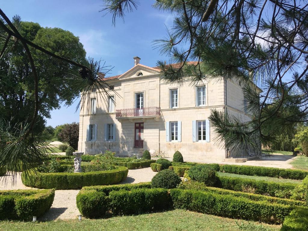 a large house with a garden in front of it at Les Croque-Notes, chambres et table d'hôtes in Lorignac