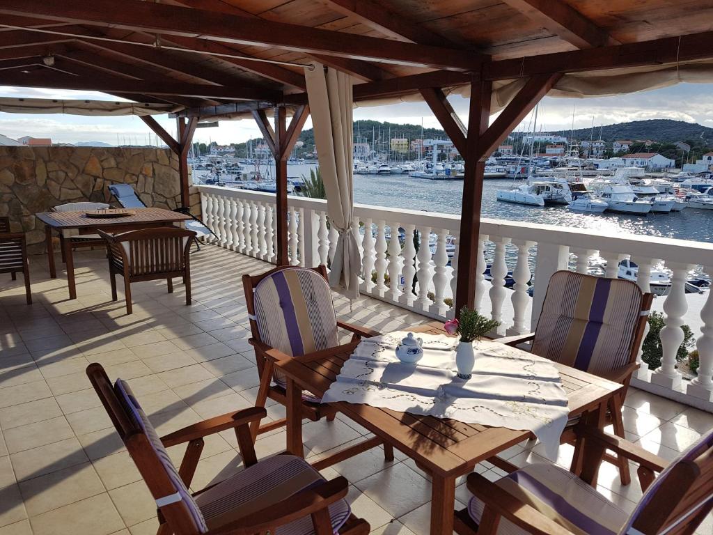 a balcony with a table and chairs and a view of a harbor at Studio apartman in Jezera