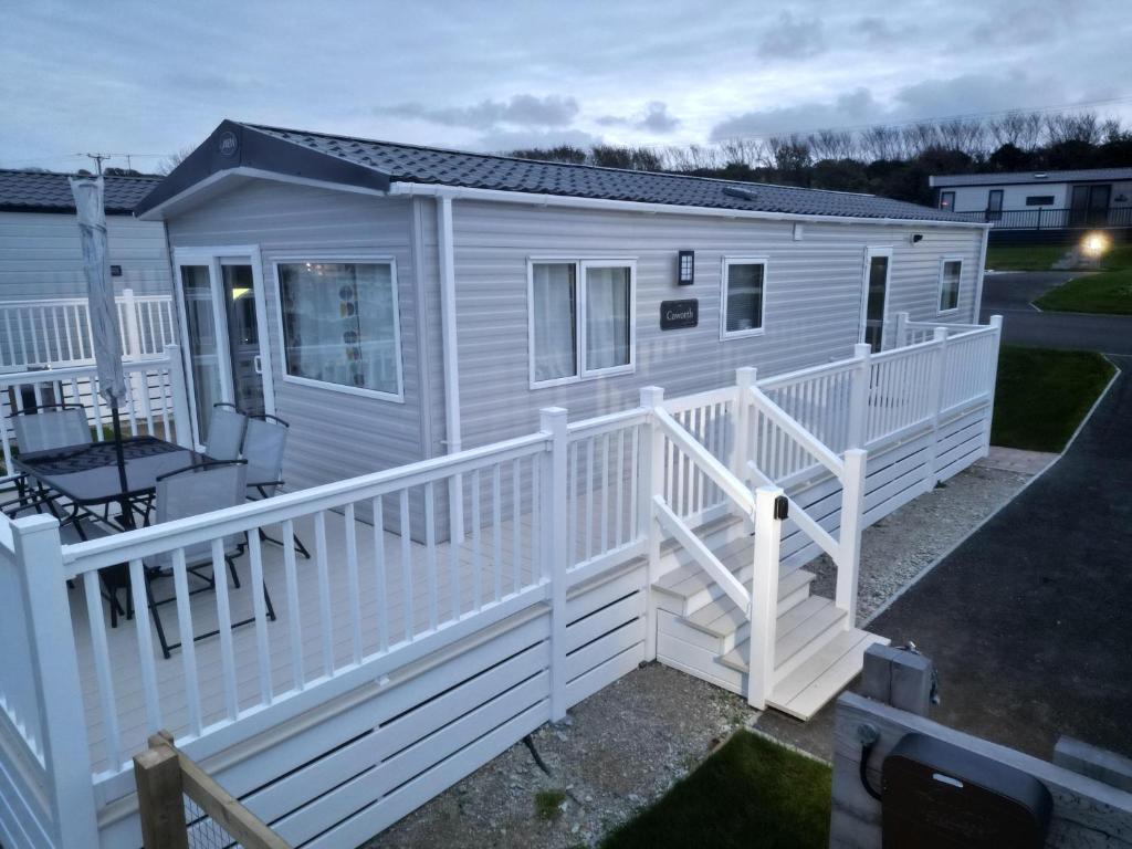 a white mobile home with a white fence at 3-Bedroom Holiday Home with Valley Views in Newquay