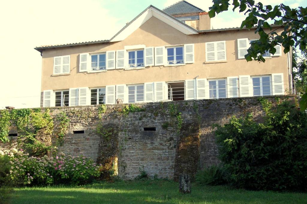 un edificio con persianas blancas en la parte superior de una pared de ladrillo en Le Montellier, en Blacé