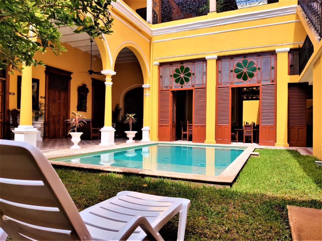 a house with a swimming pool in the yard at Hotel Real Toledo by Kavia in Mérida