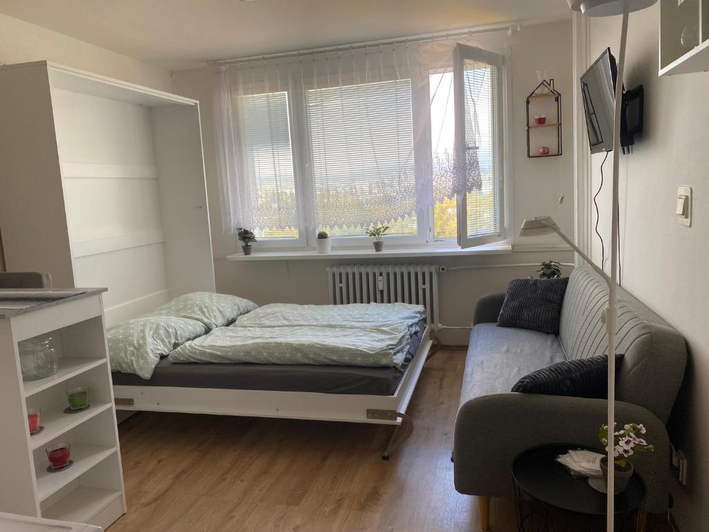 Habitación pequeña con cama y sofá en Skvelo zariadená garsonka, en Martin