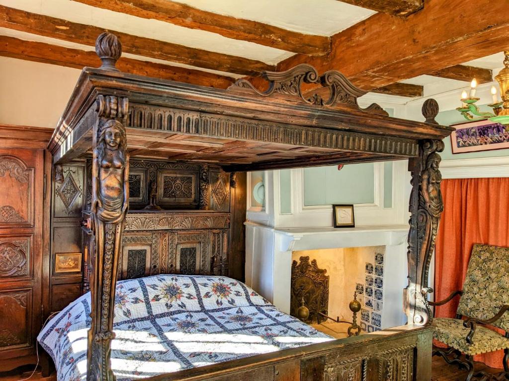 1 dormitorio con cama de madera con dosel en una habitación en House of secrets, en Morlaix