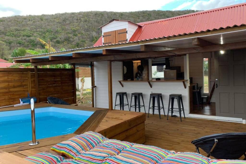 une terrasse avec une piscine et une maison dans l'établissement La tiny de titanse avec piscine, à Cadet