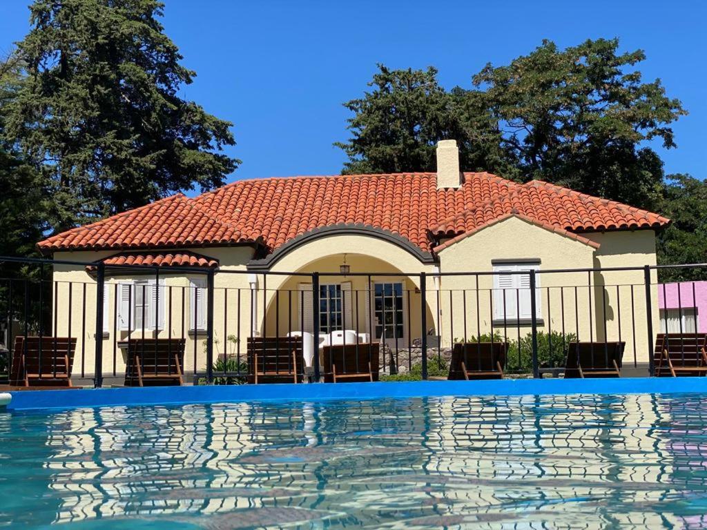 a house with a pool in front of it at Apart Hotel Naga Huel in Sierra de la Ventana