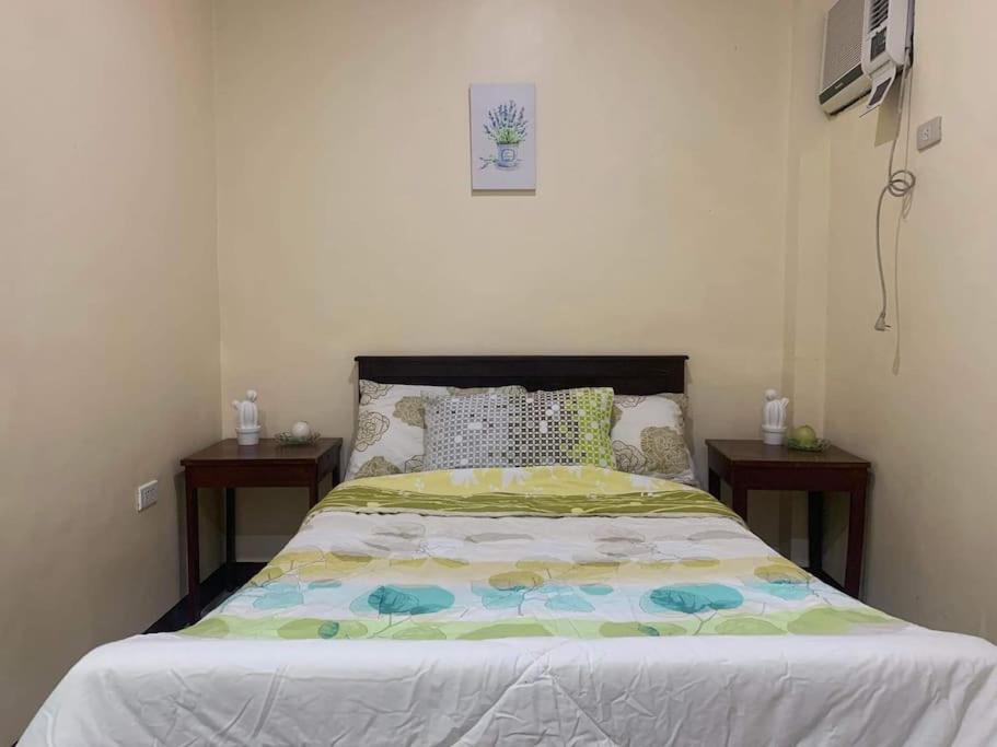 a bed in a bedroom with two night stands at S & E homes 2 in Babuy