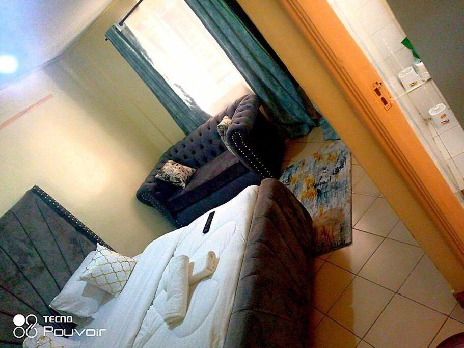 a view of a bedroom with a bed and a couch at Attic place South B. in Nairobi