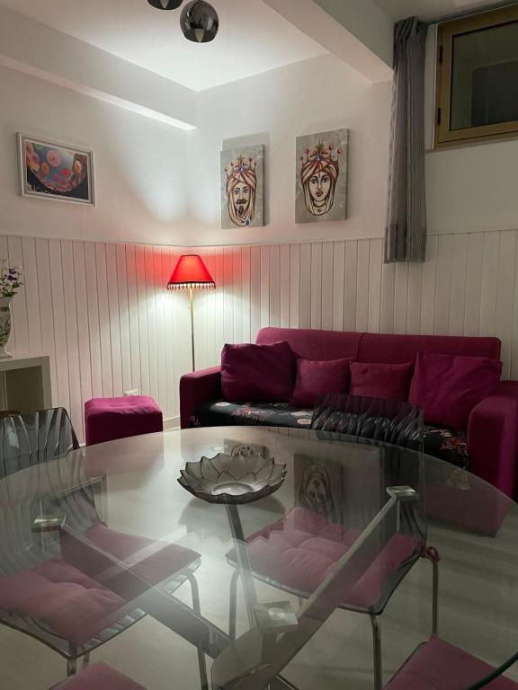 een woonkamer met een rode bank en een glazen tafel bij CAPOLINEA in Roccalumera