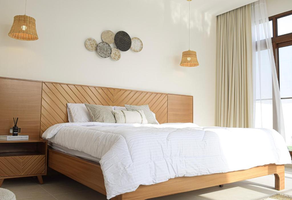1 dormitorio con 1 cama grande y cabecero de madera en Flora chalet, en Ḩifrī