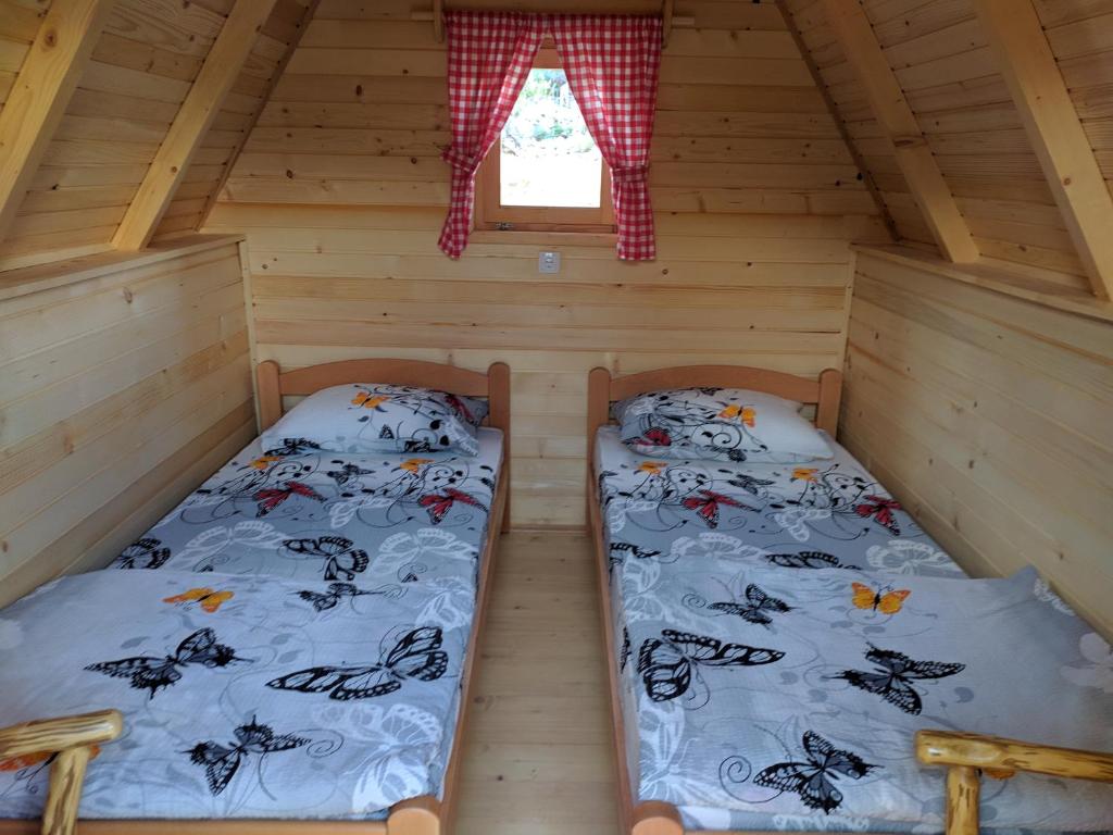 トレビニェにあるRural Tourism/Ruralni Turizam Kisinのログキャビン内のベッドルーム1室(ベッド2台付)