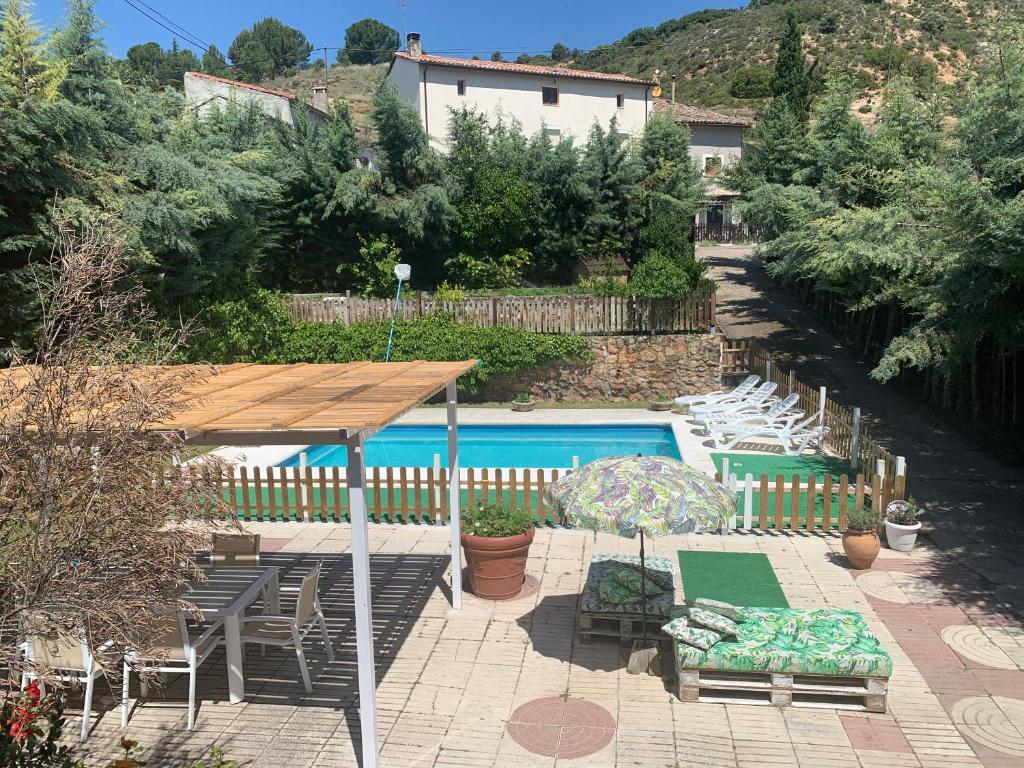 uma piscina com mesa e cadeiras ao lado em Casa Rural Serafïn, Pet Friendly em Renera